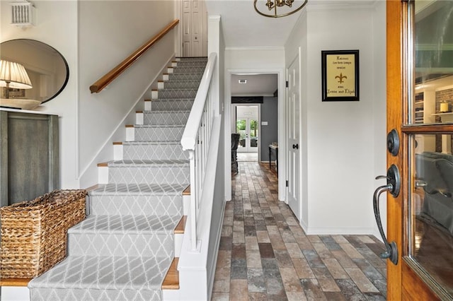 616 Marilyn Dr, Mandeville, LA 70448 - stairway featuring crown molding, visible vents, brick floor, and baseboards