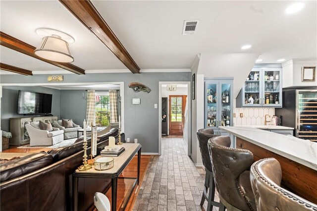 616 Marilyn Dr, Mandeville, LA 70448 - living area featuring visible vents, baseboards, ornamental molding, beam ceiling, and brick floor