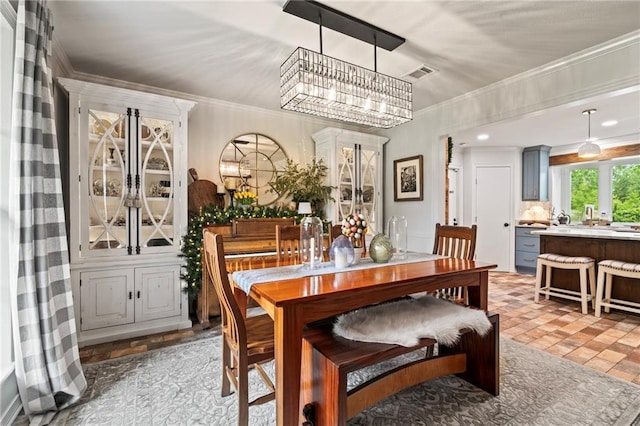 616 Marilyn Dr, Mandeville, LA 70448 - dining room featuring an inviting chandelier, ornamental molding, and visible vents