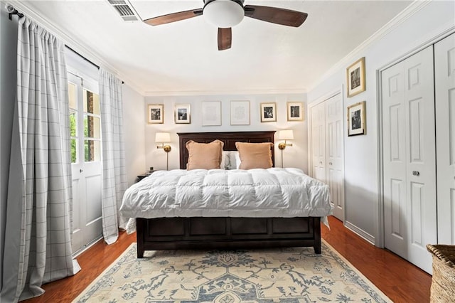 616 Marilyn Dr, Mandeville, LA 70448 - bedroom with two closets, ceiling fan, ornamental molding, visible vents, and wood finished floors