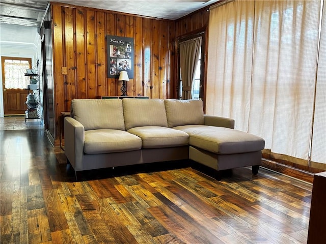 living room with crown molding, wood walls, and wood-type flooring