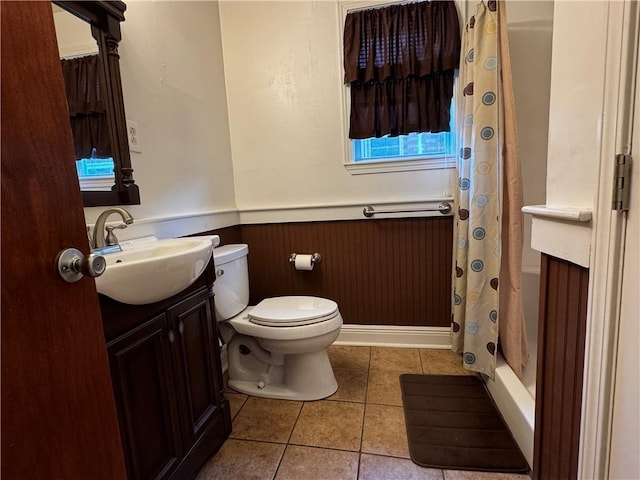 full bath with a shower with curtain, toilet, wainscoting, vanity, and tile patterned floors