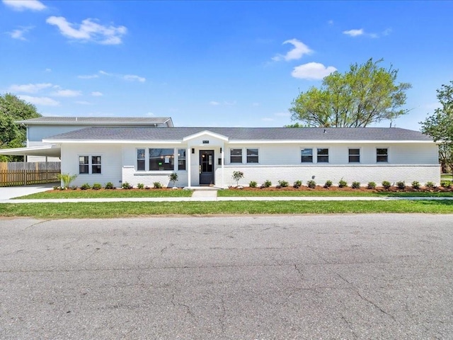 single story home with driveway, a front yard, fence, and an attached carport