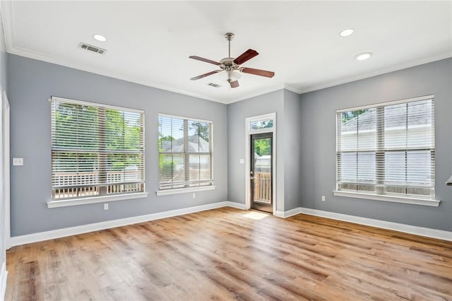spare room featuring ornamental molding, wood finished floors, visible vents, and ceiling fan