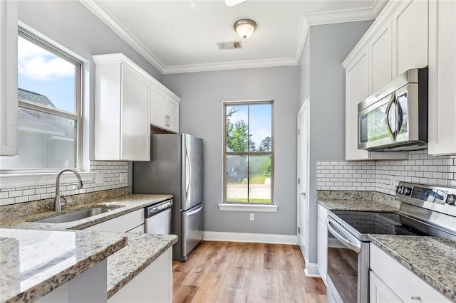 kitchen featuring a sink, tasteful backsplash, visible vents, white cabinetry, and appliances with stainless steel finishes