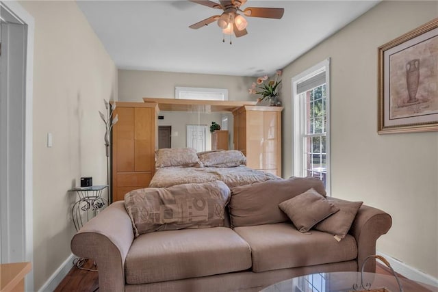 bedroom with wood finished floors, baseboards, and ceiling fan