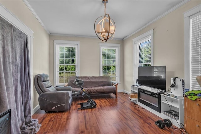 sitting room featuring an inviting chandelier, crown molding, a healthy amount of sunlight, and baseboards