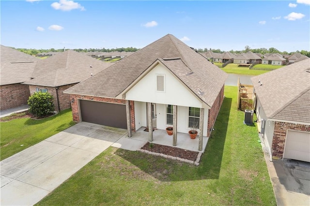 42403 Tigers Eye Stone Ave, Prairieville, LA 70769 - view of front of property featuring a shingled roof, central air condition unit, concrete driveway, brick siding, and a garage