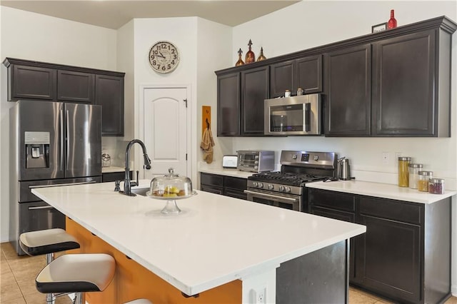 42403 Tigers Eye Stone Ave, Prairieville, LA 70769 - kitchen featuring stainless steel appliances, a breakfast bar, a kitchen island with sink, and light countertops