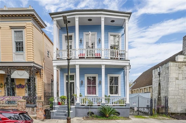 1323 Esplanade Ave Unit C, New Orleans, LA 70116 - view of front of home featuring covered porch, a balcony, and fence