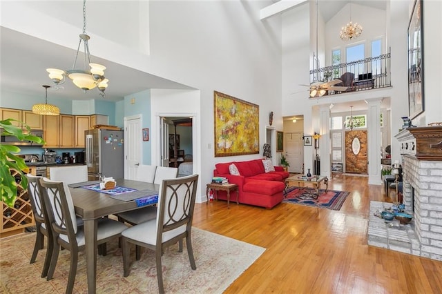 2820 Desoto St, New Orleans, LA 70119 - dining room with a chandelier, high vaulted ceiling, light wood-type flooring, ornate columns, and baseboards