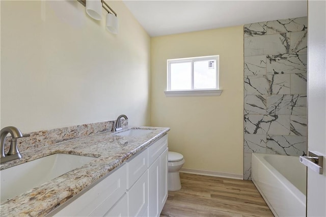 4536 Laine Ave, New Orleans, LA 70126 - bathroom featuring toilet, double vanity, wood finished floors, baseboards, and shower / bathtub combination