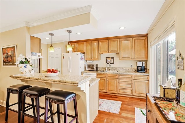 9621 Charlotte Dr, River Ridge, LA 70123 - kitchen featuring white appliances, a kitchen bar, crown molding, light wood-type flooring, and hanging light fixtures