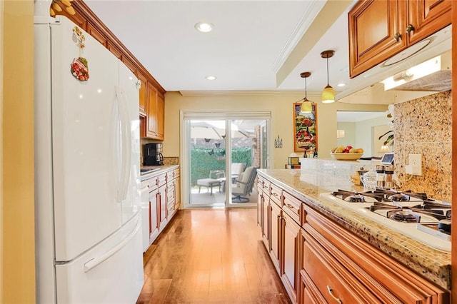 9621 Charlotte Dr, River Ridge, LA 70123 - kitchen featuring white appliances, light wood-style floors, under cabinet range hood, crown molding, and brown cabinetry