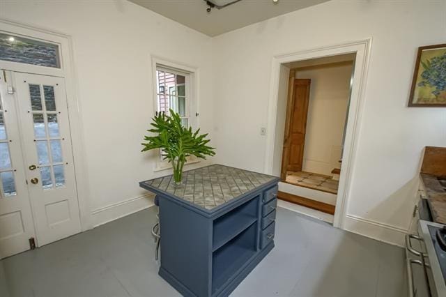 doorway with baseboards and finished concrete floors
