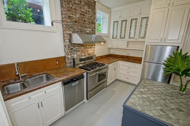 kitchen with a sink, glass insert cabinets, stainless steel appliances, white cabinetry, and under cabinet range hood