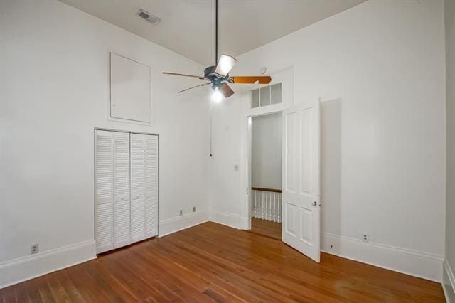 unfurnished bedroom featuring baseboards, wood finished floors, and visible vents