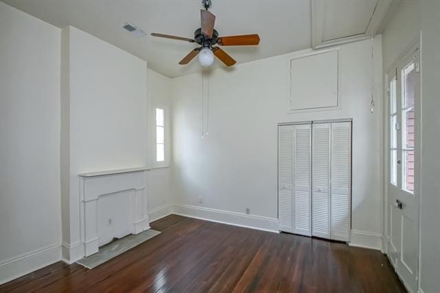 unfurnished bedroom featuring baseboards, dark wood-type flooring, and multiple windows
