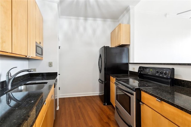 kitchen featuring dark wood-style floors, ornamental molding, a sink, dark stone counters, and appliances with stainless steel finishes