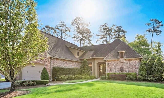 view of front of property featuring stucco siding, a front lawn, and brick siding
