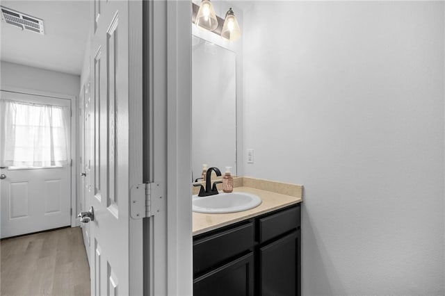 bathroom with wood finished floors, visible vents, and vanity
