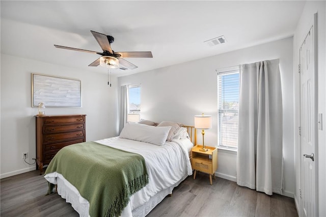 bedroom featuring multiple windows, wood finished floors, and visible vents