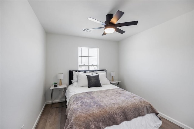 bedroom featuring visible vents, a ceiling fan, baseboards, and dark wood-style flooring