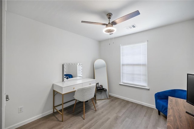 office featuring light wood finished floors, baseboards, a ceiling fan, and visible vents