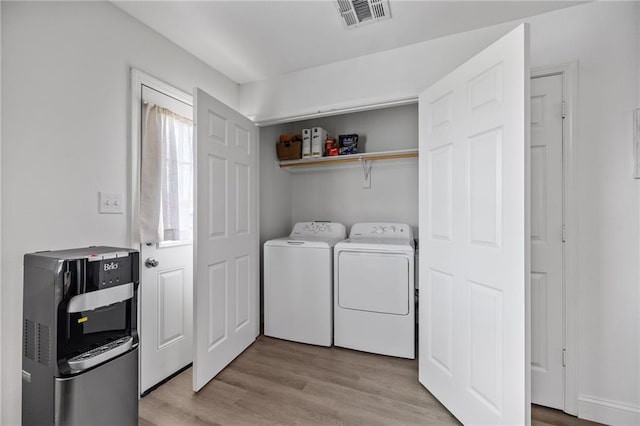 laundry area featuring separate washer and dryer, laundry area, visible vents, and light wood-style flooring