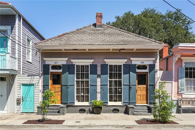 925 Touro St, New Orleans, LA 70116 - exterior space with a chimney and roof with shingles