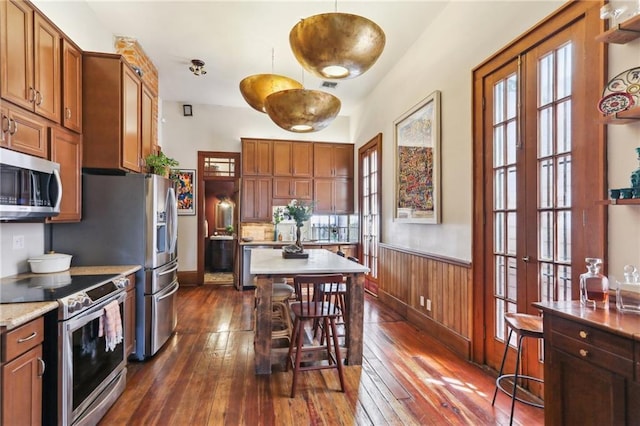 925 Touro St, New Orleans, LA 70116 - kitchen featuring light countertops, dark wood finished floors, a healthy amount of sunlight, and appliances with stainless steel finishes