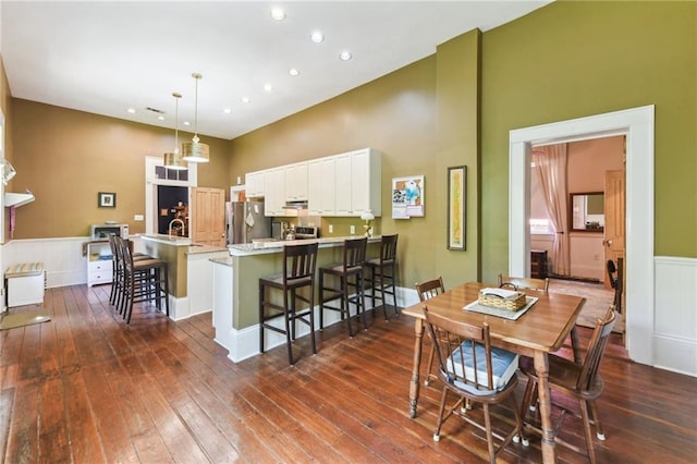 618 Belleville St, New Orleans, LA 70114 - dining room with recessed lighting, dark wood finished floors, a towering ceiling, and wainscoting