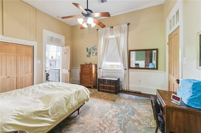 618 Belleville St, New Orleans, LA 70114 - bedroom featuring wood finished floors, ceiling fan, a wainscoted wall, ensuite bath, and visible vents