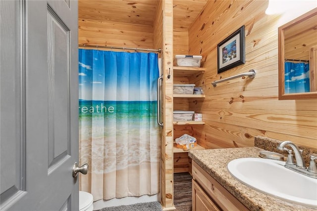 bathroom featuring vanity, curtained shower, wooden walls, wooden ceiling, and toilet