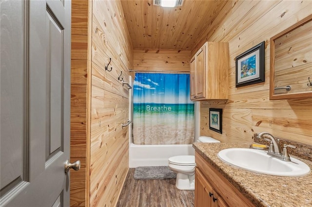 bathroom with wood walls, wood finished floors, toilet, vanity, and wood ceiling