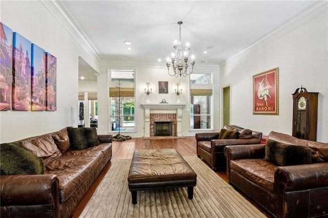 living room featuring crown molding, wood finished floors, an inviting chandelier, a fireplace, and recessed lighting