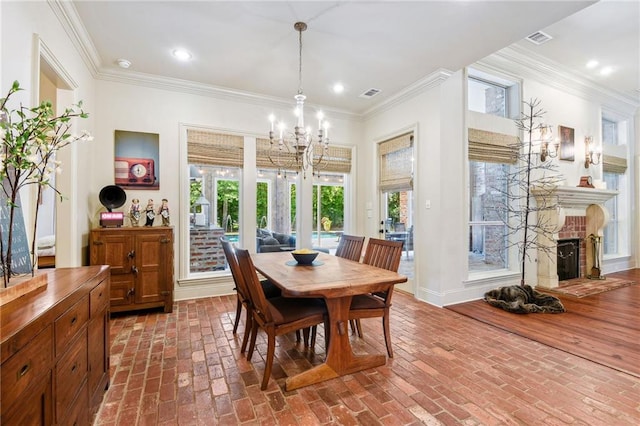 dining space featuring recessed lighting, a fireplace, brick floor, crown molding, and a chandelier
