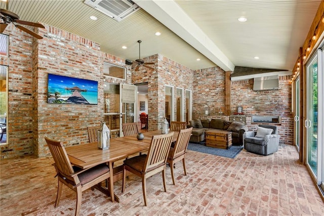 dining room featuring ceiling fan, lofted ceiling with beams, brick wall, and brick floor