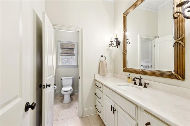bathroom with tile patterned floors, toilet, vanity, ornamental molding, and baseboards
