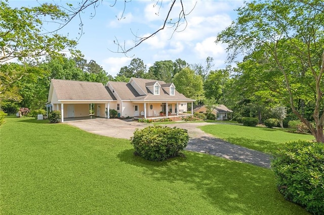 view of front of home featuring aphalt driveway, a front yard, an attached carport, and covered porch