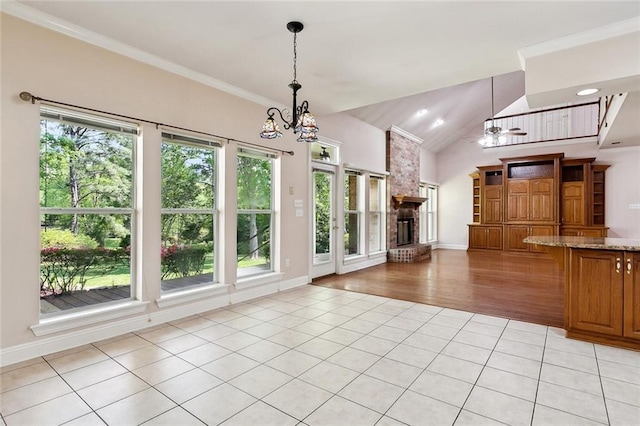 unfurnished living room featuring lofted ceiling, light tile patterned flooring, a chandelier, and plenty of natural light