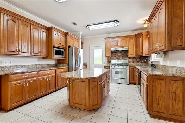 kitchen featuring brown cabinetry, under cabinet range hood, stainless steel appliances, and visible vents