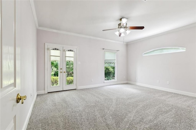 carpeted spare room with a ceiling fan, baseboards, ornamental molding, and french doors