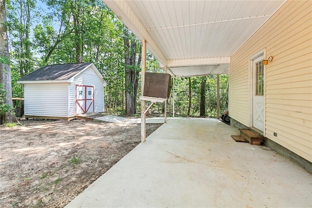 view of patio with an outdoor structure, entry steps, an attached carport, and a shed