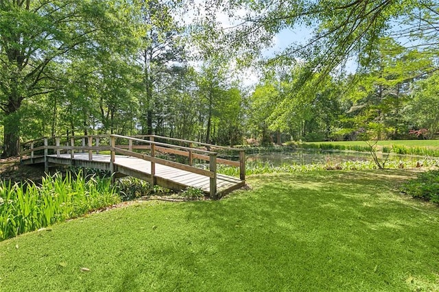 surrounding community with a lawn and a water view