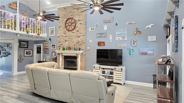 living area featuring baseboards, wood finished floors, high vaulted ceiling, and ceiling fan