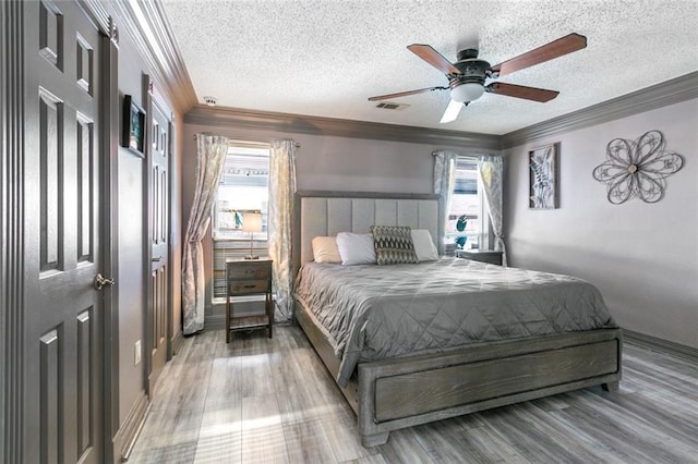bedroom featuring ornamental molding, multiple windows, and visible vents