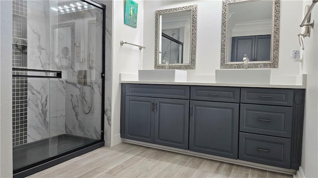 full bath featuring ornamental molding, a sink, a marble finish shower, and double vanity