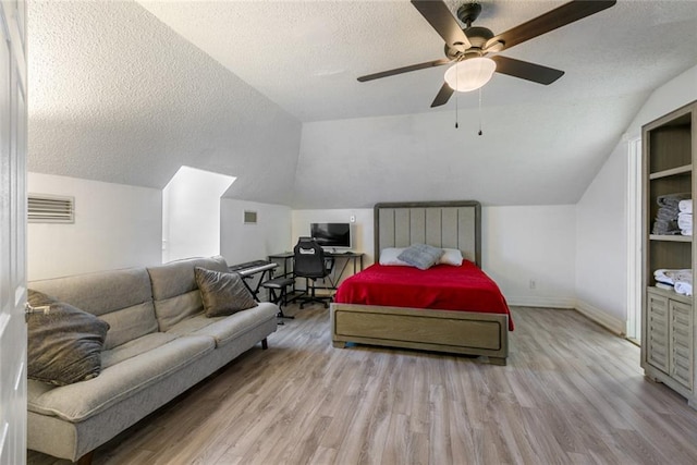 bedroom with wood finished floors, a textured ceiling, ceiling fan, baseboards, and lofted ceiling