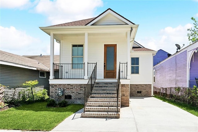 606 Whitney Ave, New Orleans, LA 70114 - view of front of home featuring a porch, a front yard, fence, and a shingled roof